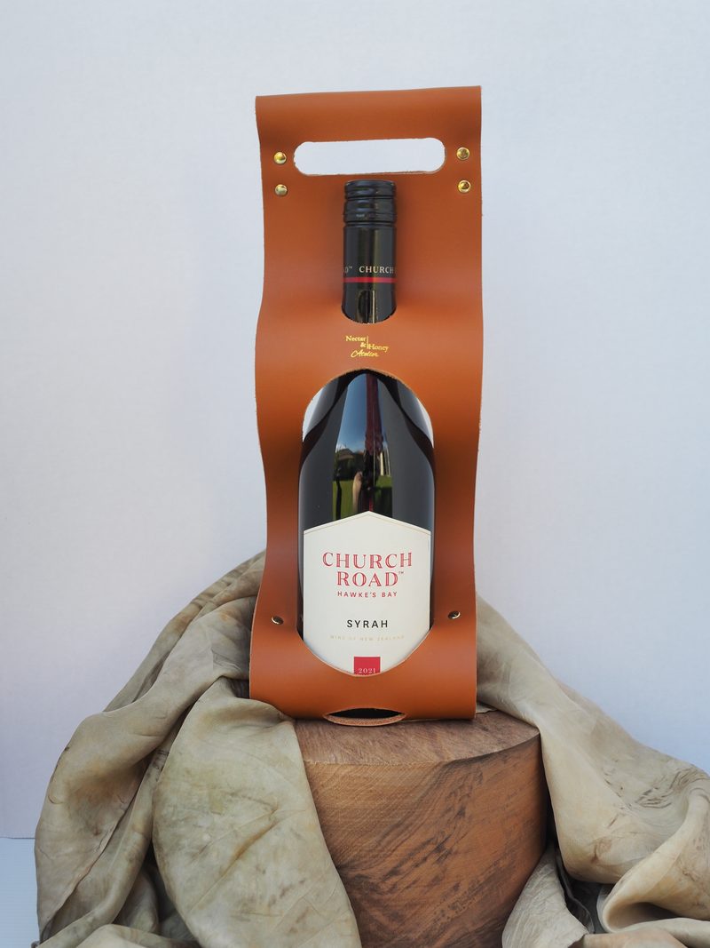Tan leather wine carrier cradling a bottle of Church Road Syrah