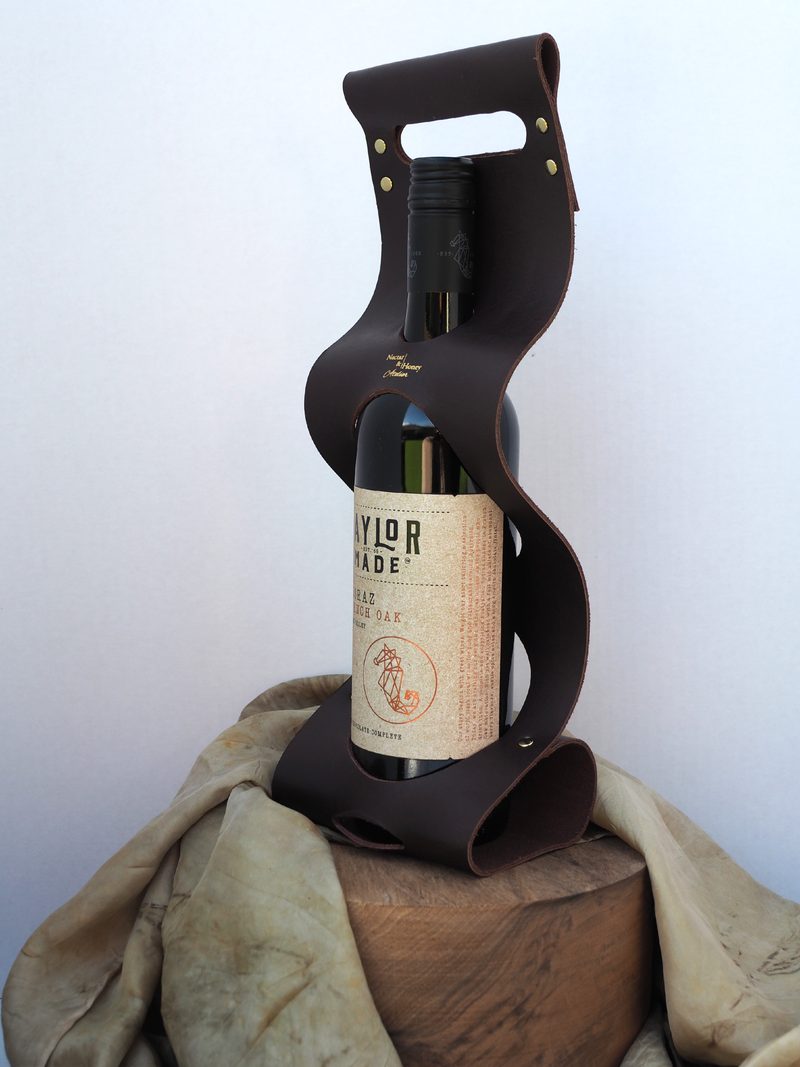 Chocolate-brown leather wine carrier with its sculpted S-curve silhouette