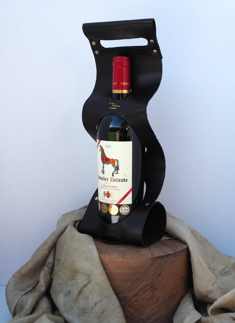 Black leather wine carrier holding a bottle of Chevalier Delaude red